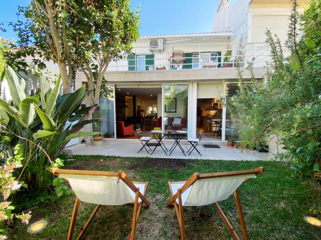 two chairs in the yard of a house at Casa das Boganvilias - Moradia com jardim in Lisbon