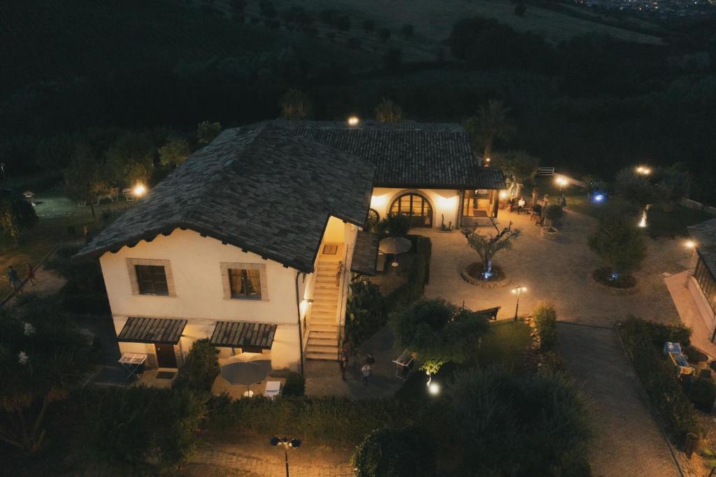 a large white house with a thatched roof at night at Country House Il Cascinale in Colonnella