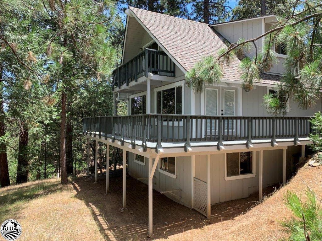 une grande maison avec une grande terrasse dans les bois dans l'établissement Breckenridge Chalet near Yosemite. Dog friendly!, à Groveland