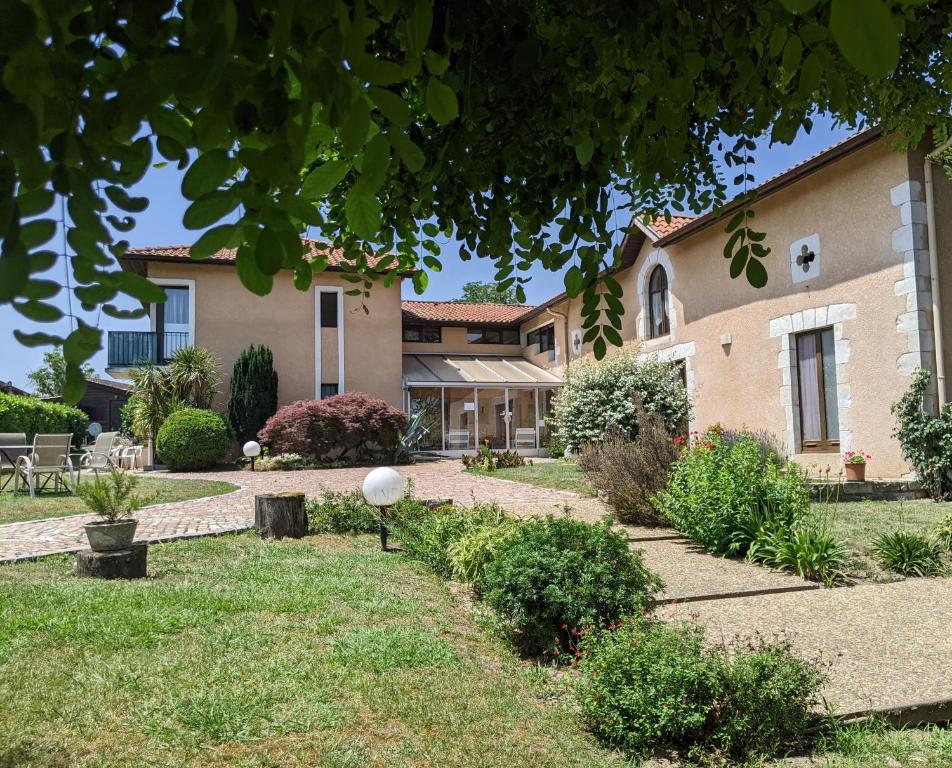 zewnętrzny widok na dom z dziedzińcem w obiekcie Hôtel Studios Les Acacias w mieście Saint-Paul-lès-Dax