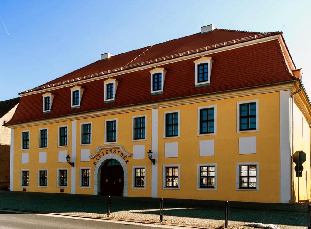 ein großes gelbes Gebäude mit rotem Dach in der Unterkunft Quartier Rautenstock GbR in Doberlug-Kirchhain