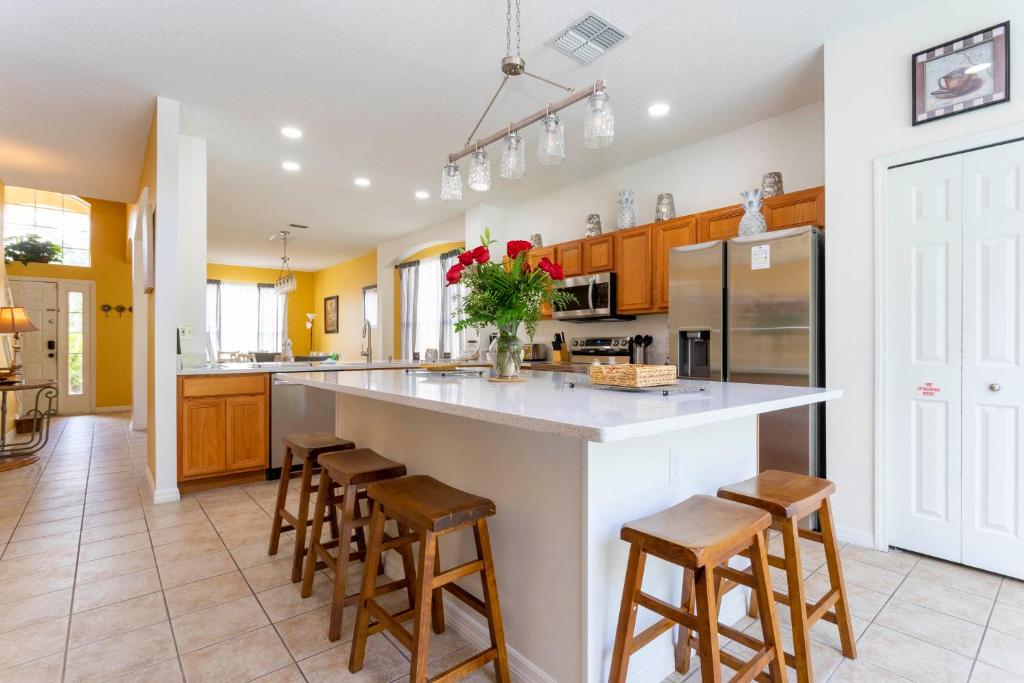 a kitchen with a large island with bar stools at 7 Bedroom Mansion Near Disney in Kissimmee