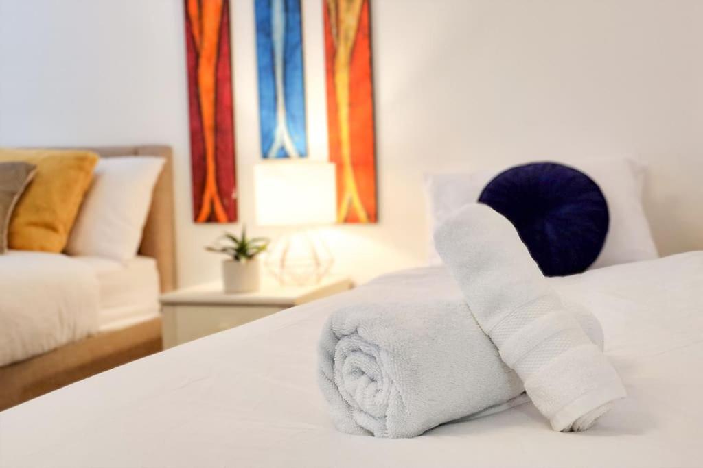 uma pilha de toalhas sentadas em cima de uma cama em Comfy 2 bed Flat with free Parking, close to Tube em Woolwich
