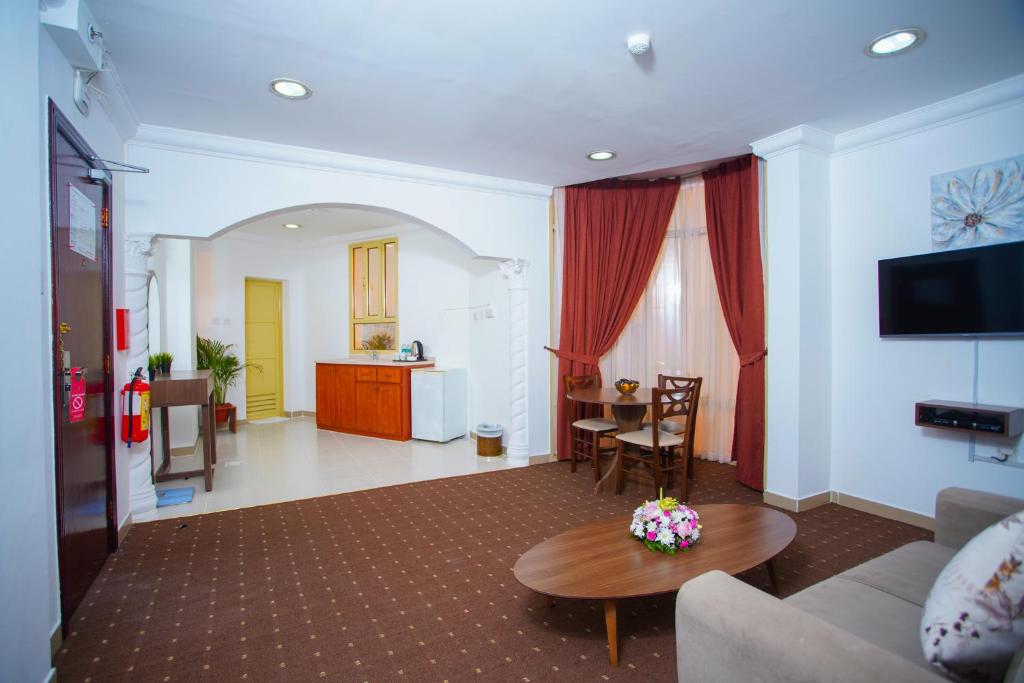 un soggiorno con un divano e un tavolo di La Villa Hotel a Doha