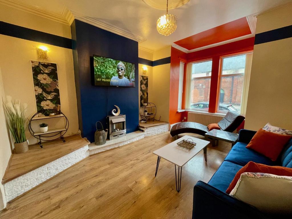 uma sala de estar com um sofá e uma televisão na parede em Kimberworth House, 4 Bedrooms, WIFI, Close to M1, Longer Stay, Free Parking em Rotherham