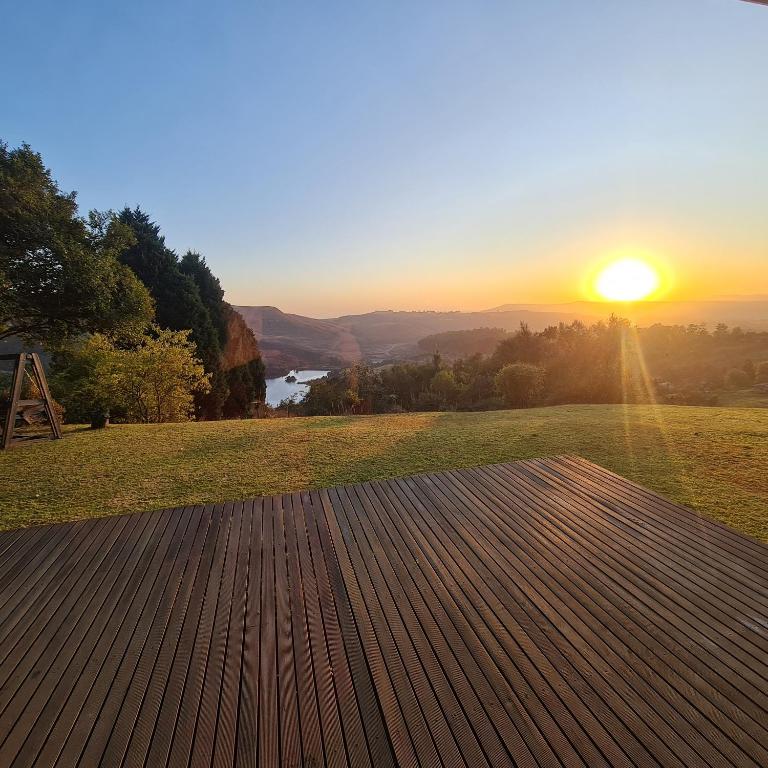Blick auf den Sonnenuntergang von einer Holzterrasse in der Unterkunft Luxury Home with breathtaking views of Champagne Valley in Bergview