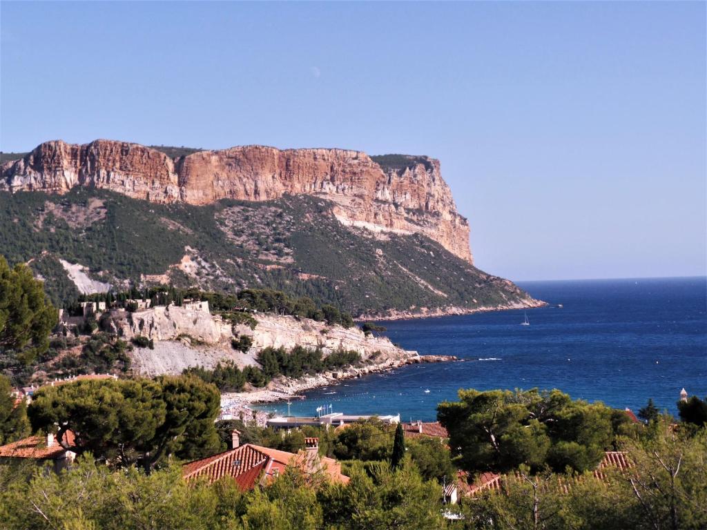 a view of a mountain and the ocean with houses at LE SEPT charmant studio aux portes des calanques in Cassis