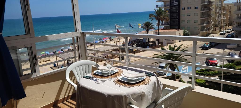 a table on a balcony with a view of the beach at Balcon al mar in Bellreguart