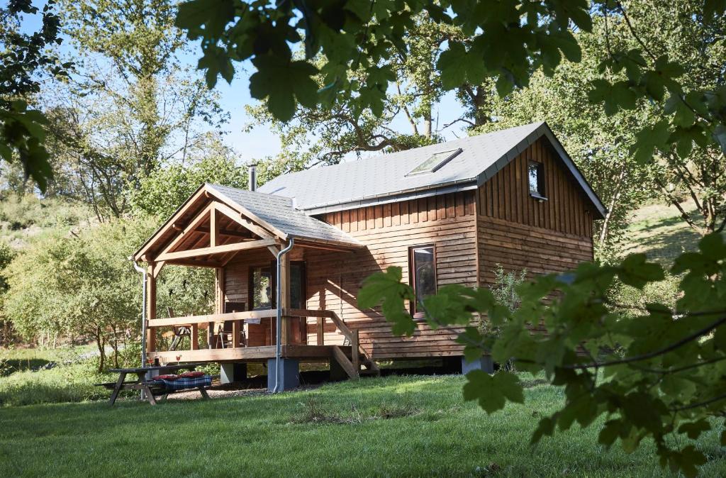 eine Blockhütte mit einer Veranda und einer Terrasse in der Unterkunft Chalet Mont Juru - Romantisch 2-persoons Chalet in Houffalize