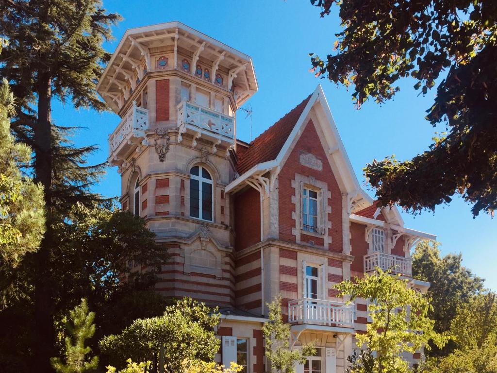 un bâtiment avec une tour d'horloge au sommet dans l'établissement Le Quatre Allée Stella Arcachon, à Arcachon