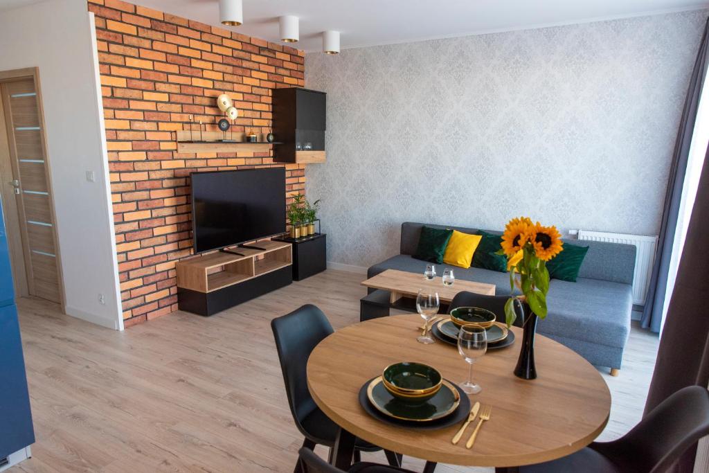 a living room with a table and a couch at Marcelina Golden Apartments przy Aquapark Reda in Rumia