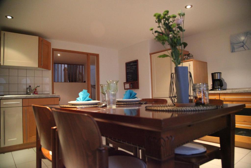 a kitchen with a wooden table with chairs and a dining room at Wunderschöne Dachgeschoss - Maisonette (108qm - 3.OG) in Rostock