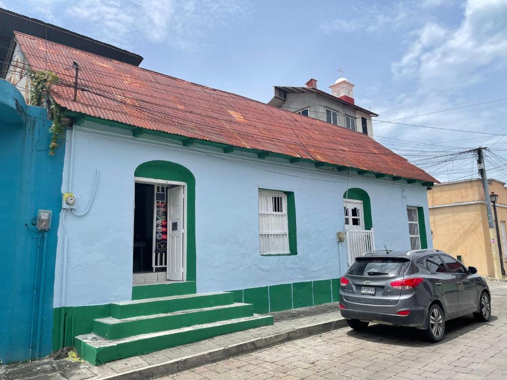 a car parked in front of a blue building at Hostal Inn 1 in Flores