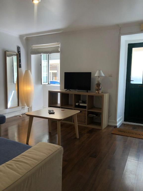 a living room with a table and a tv at Ocean Corner Belém in Lisbon