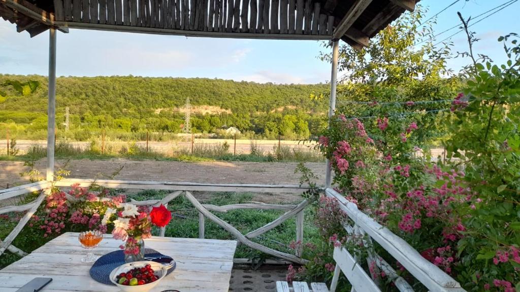 una mesa con flores y vistas a un campo en Riverside villa, en Qusar