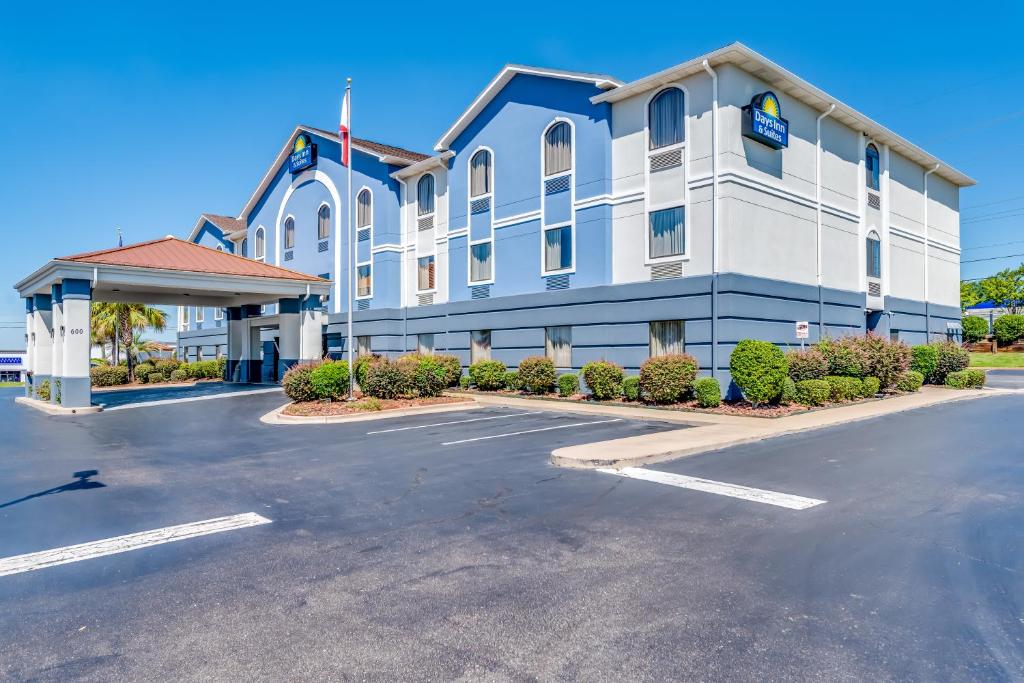 Un gran edificio azul y blanco con estacionamiento. en Days Inn & Suites by Wyndham Prattville-Montgomery, en Prattville