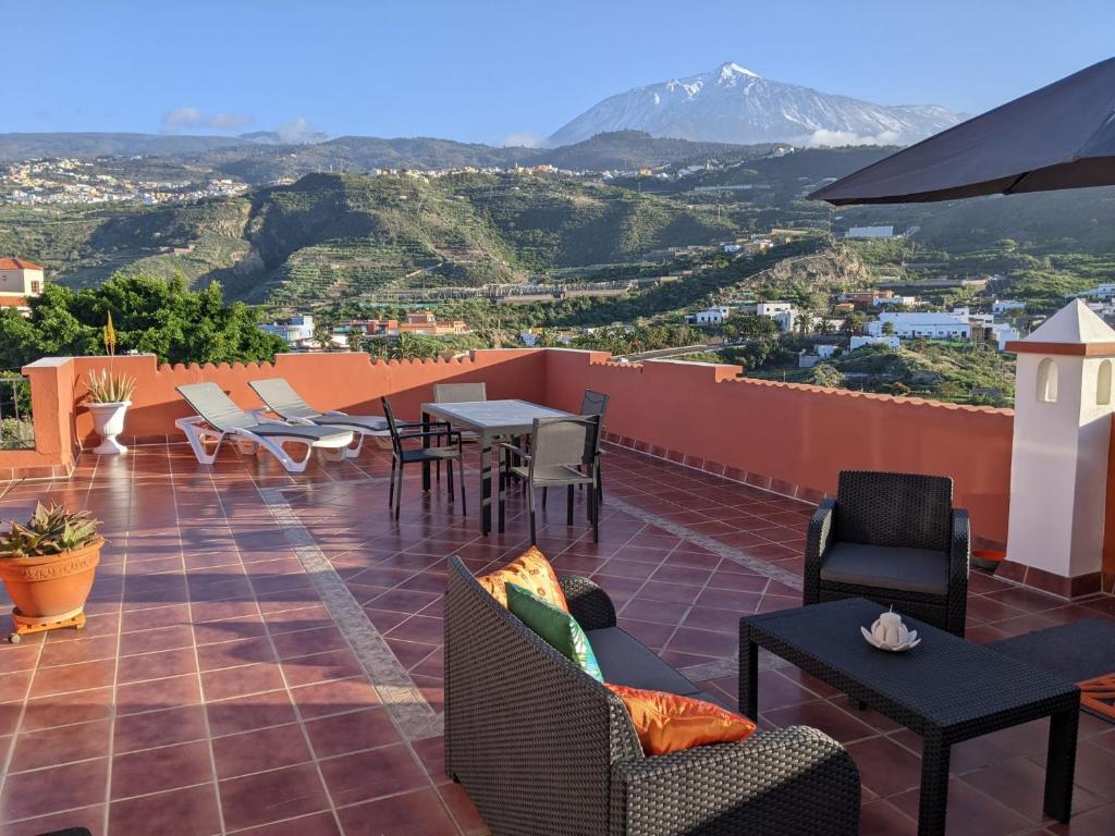 eine Terrasse mit Stühlen und Tischen und Bergblick in der Unterkunft La Casita del Sendero in La Guancha