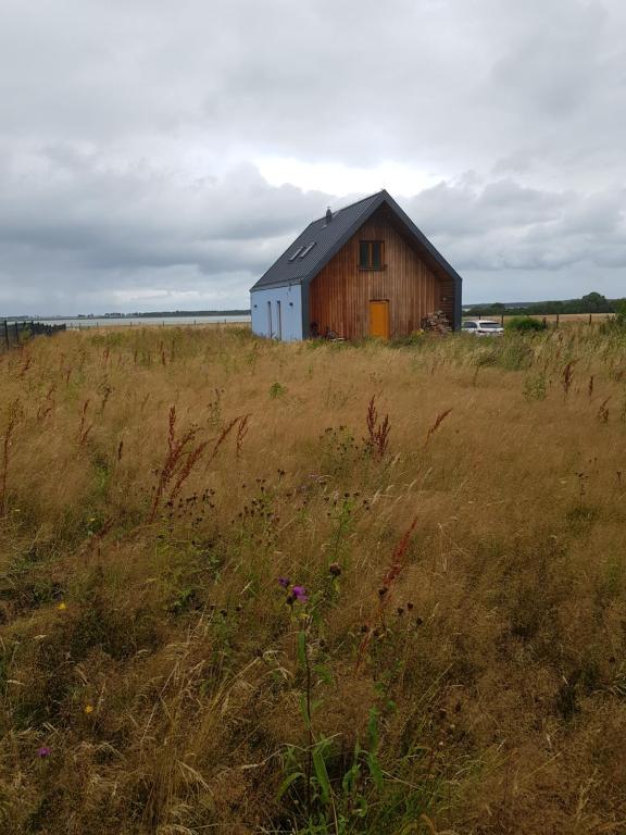un granero en medio de un campo en Błękitny domek, en Darłowo