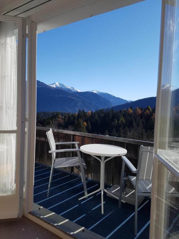 een patio met een tafel en stoelen op een balkon bij Casa Crap in Trin