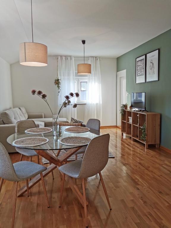 ein Wohnzimmer mit einem Tisch, Stühlen und einem Sofa in der Unterkunft Forest 88 apartment in Mostar