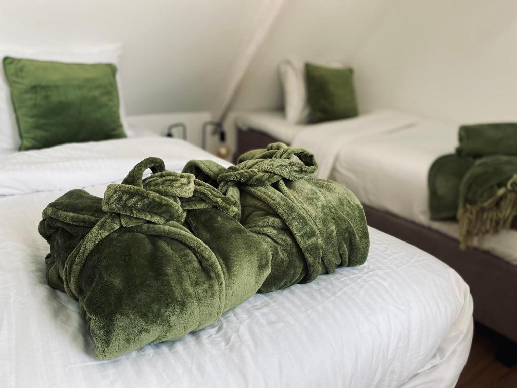 une couverture verte assise au-dessus d'un lit dans l'établissement Ambiance, à Hollum