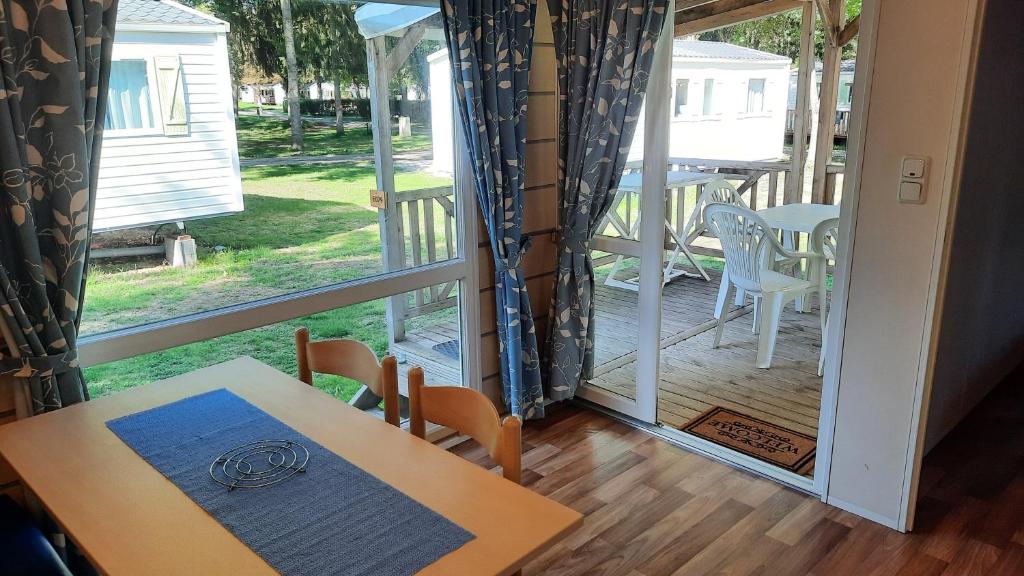 widok na werandę ze stołem i krzesłami w obiekcie Le Ried Camping To hapi w mieście Boofzheim