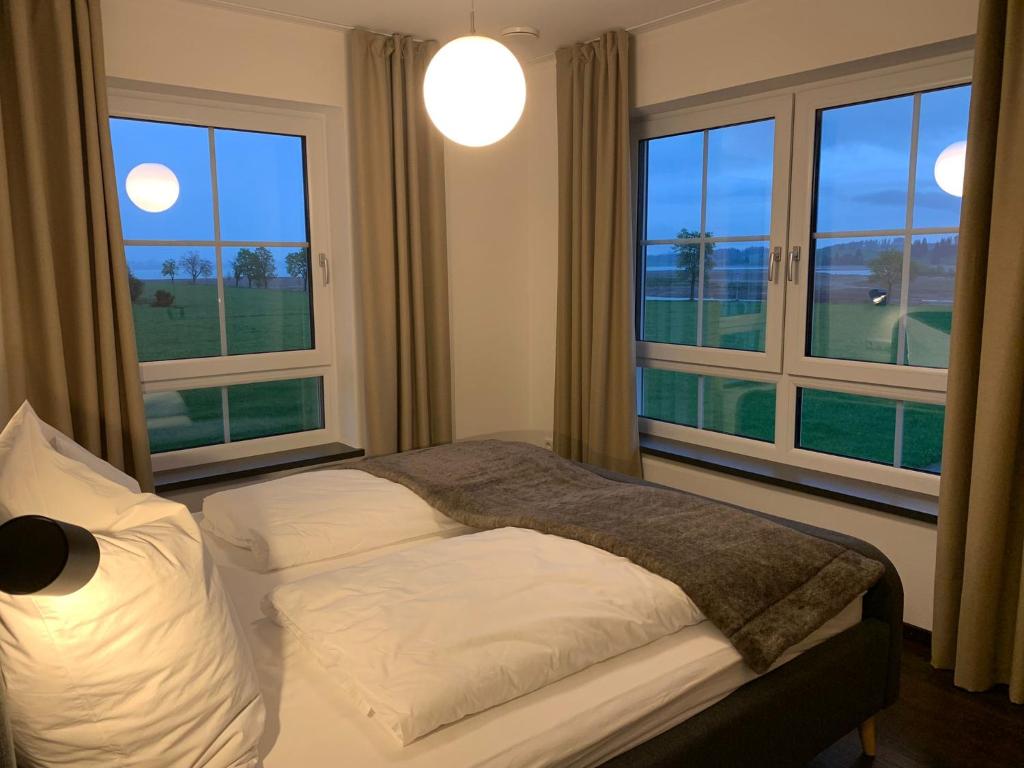a bedroom with two beds and two large windows at Ferienwohnung Seestadel in Schwangau