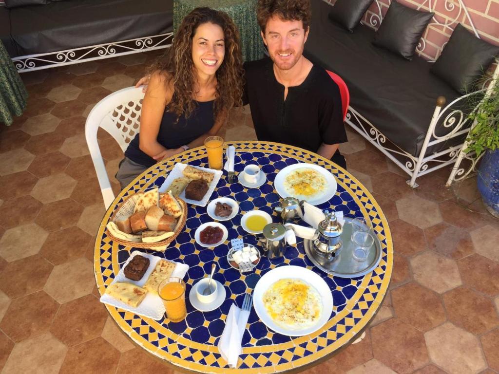 a man and a woman sitting at a table with food at Hotel salem leksor in Marrakech