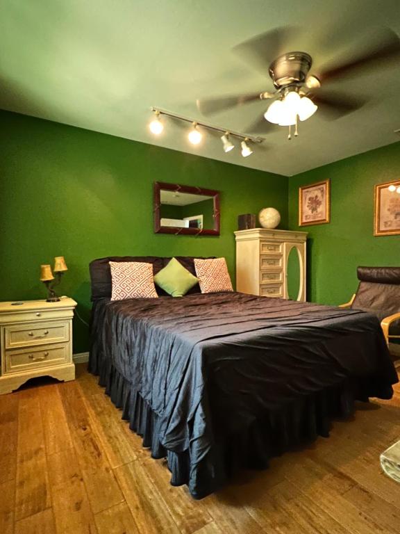 a bedroom with green walls and a large bed at Beautiful Foothill Living in Rancho Cucamonga