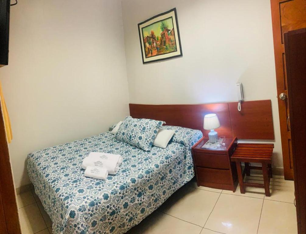 Un dormitorio con una cama y una mesa con toallas. en Imperial Inn Hospedaje Turistico, en Lima