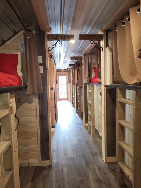 a room with many bunk beds and a hallway at THE ORCHARD (HOSTEL WITH PRIVATE BUNKS) in Radium Hot Springs