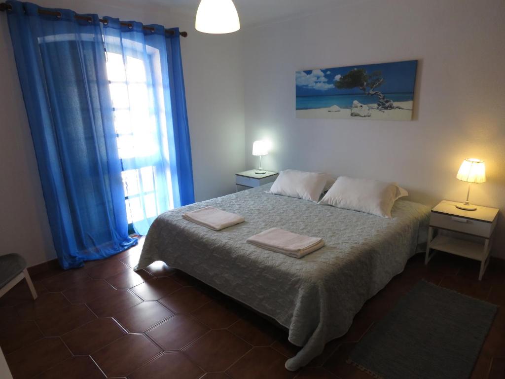 a bedroom with a bed with two towels on it at Casas da praia Supertubos in Peniche