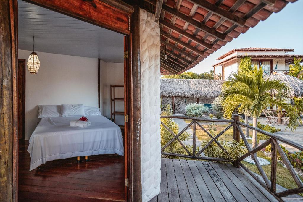 1 dormitorio con 1 cama en una terraza de madera en Pousada Juventus en Barra Grande