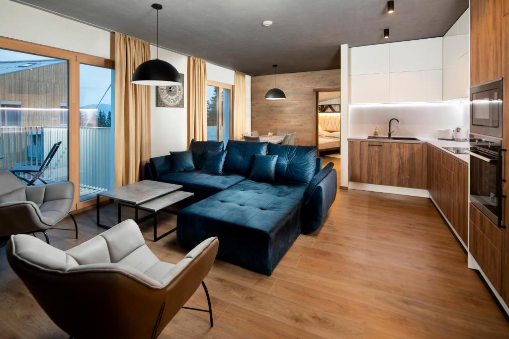 uma sala de estar com um sofá azul e uma cozinha em Hillside Y41 em Dolný Kubín