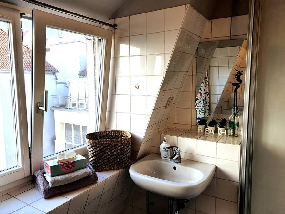 a bathroom with a sink and a window at Rostock hautnah erleben - schöne Maisonette 2OG in Rostock