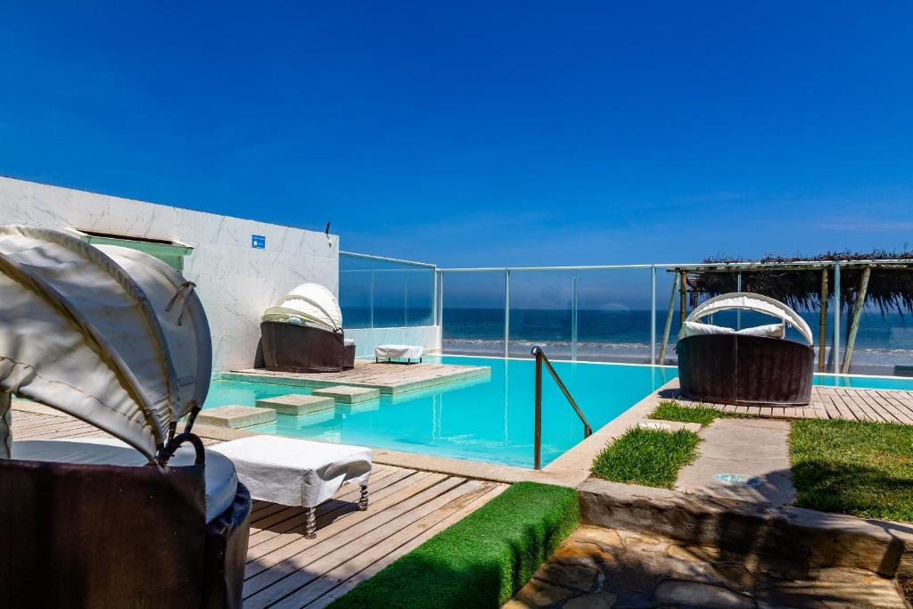 a swimming pool with a view of the ocean at Hotel Del Mar Mancora in Máncora