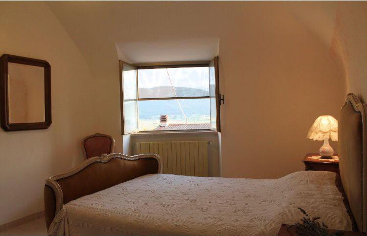 a bedroom with a bed and a window at Casetta Mimì in San Pio delle Camere
