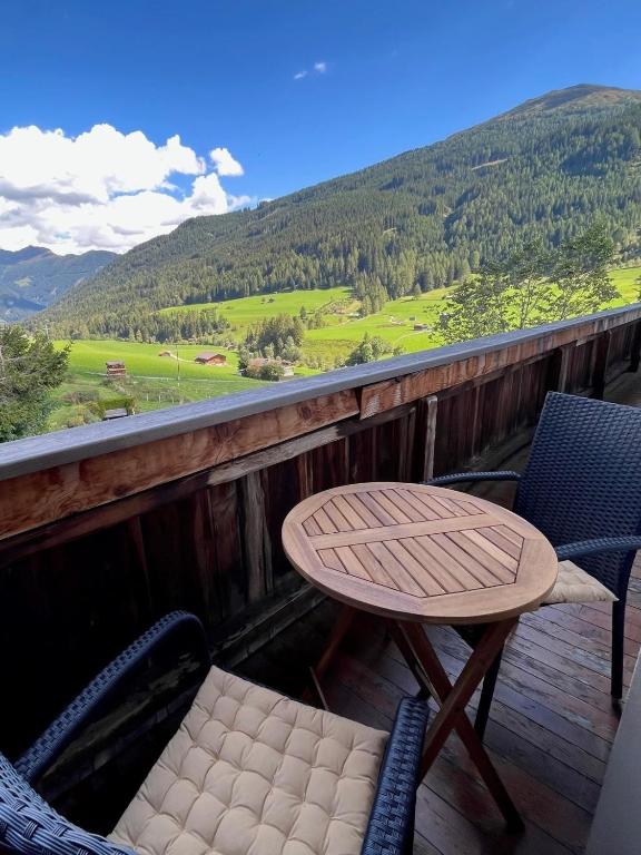 a table and chairs on a deck with a view of a mountain at Pranger Hof in Trins