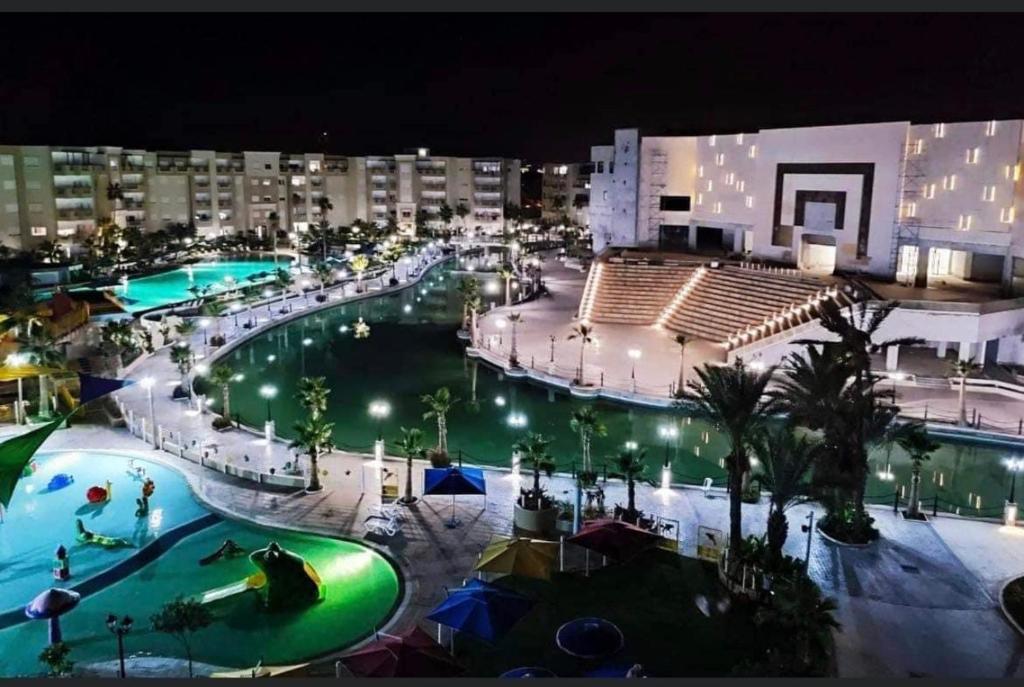 a view of a large swimming pool at night at PALM LAKE RESORT FOLLA in Monastir