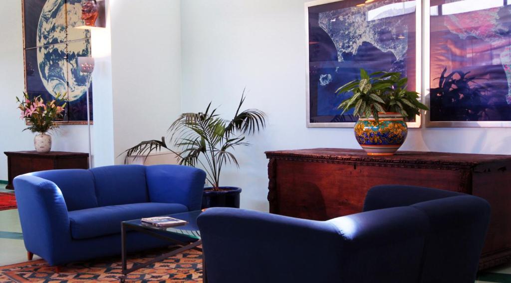 a living room with two blue chairs and a table at Rada Siri in Montepaone