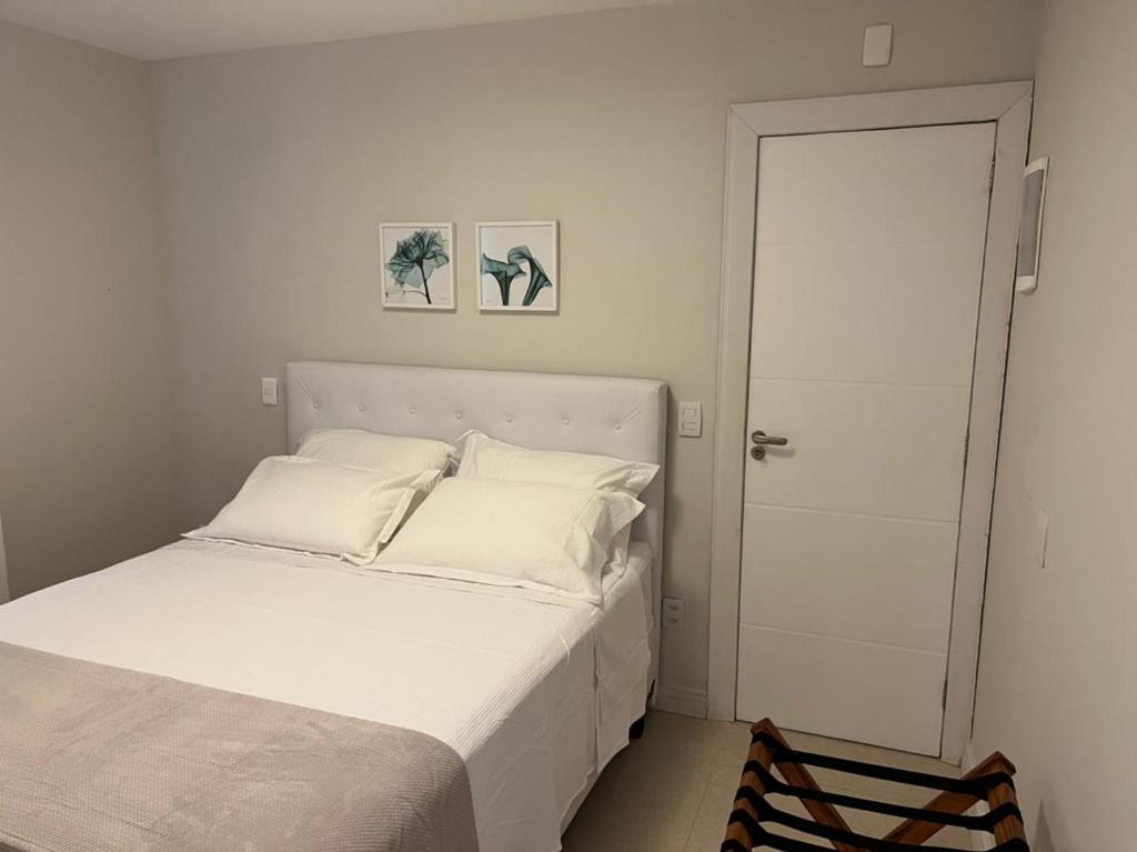 a bedroom with a white bed and a white door at Melhor localização Leblon, apartamento reformado in Rio de Janeiro