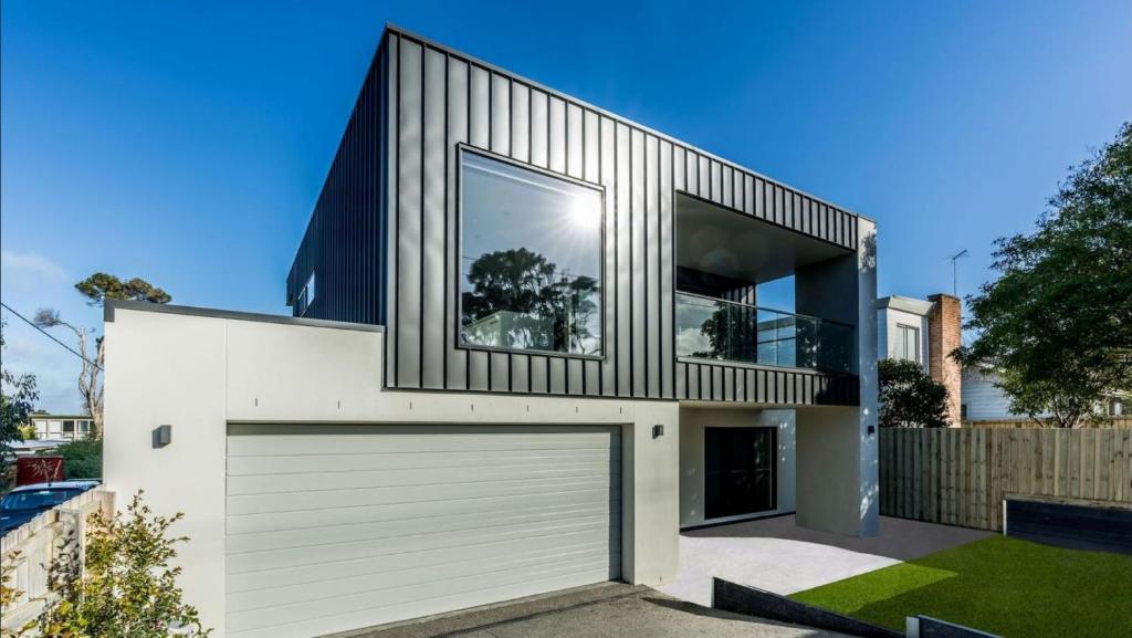 a house with a garage and a large window at Luxury on Bayview Wifi Linen included in Inverloch