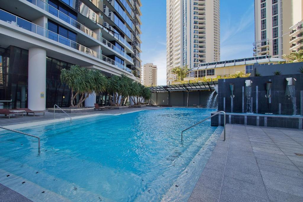 a large swimming pool in a city with tall buildings at Circle on Cavill - QStay in Gold Coast