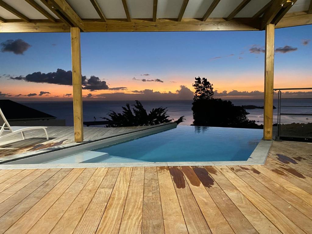 a swimming pool with a view of the ocean at Calypso Bay in Bouillante