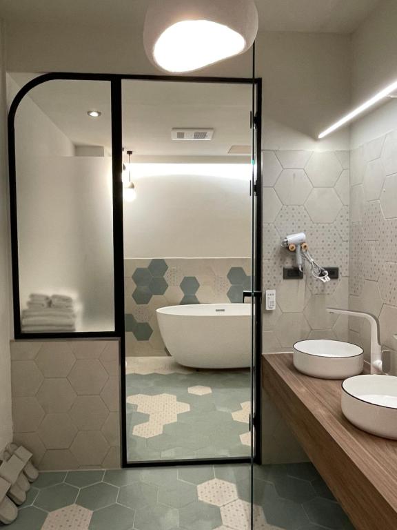 a bathroom with a tub and two sinks and a shower at Green Inn Kaohsiung in Kaohsiung