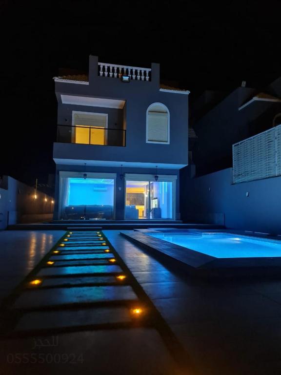 a house with a swimming pool at night at فيلا بشاطي رملي خاص ومسبح عالبحر - درة العروس شاطي البردايس in Durat  Alarous