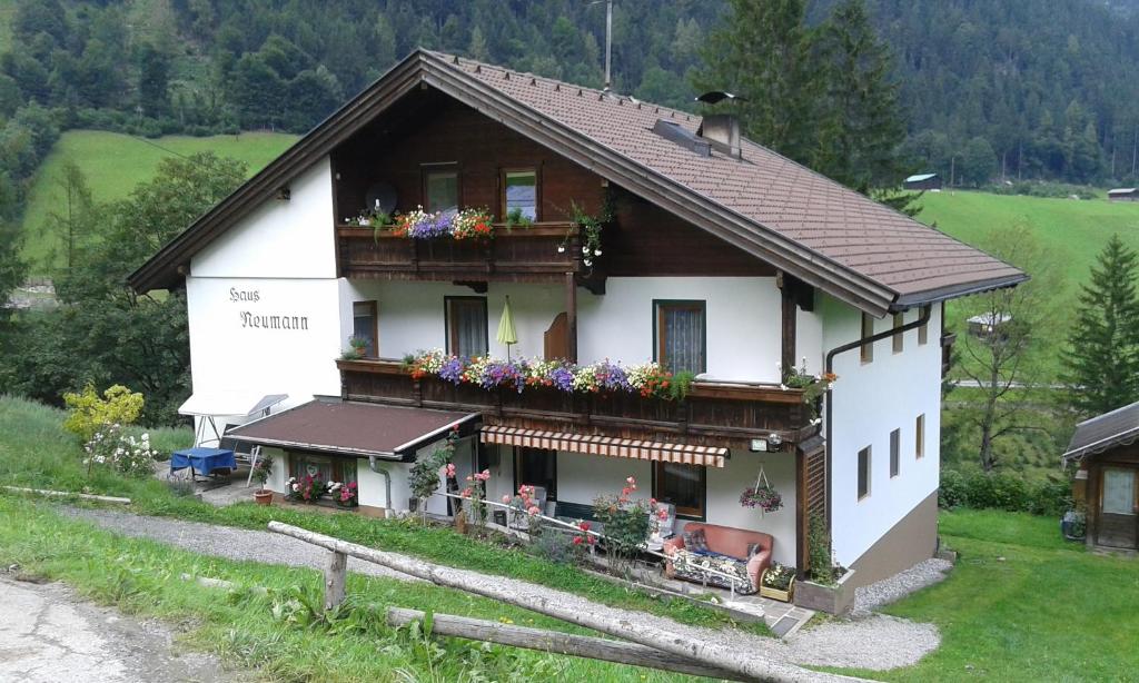 a white house with flowers on the balcony at Appartement Neumann in Finkenberg