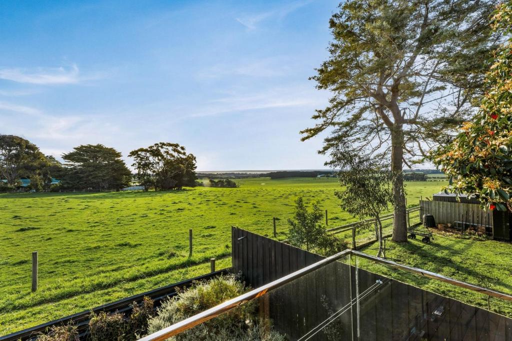 um campo de relva verde com uma cerca e uma árvore em Castlebay em Wimbledon Heights