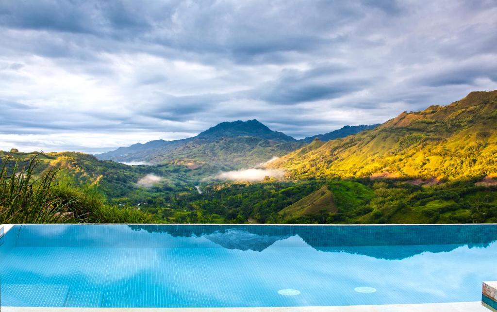 a swimming pool with a view of mountains at Hacienda Buenavista in Quimbaya