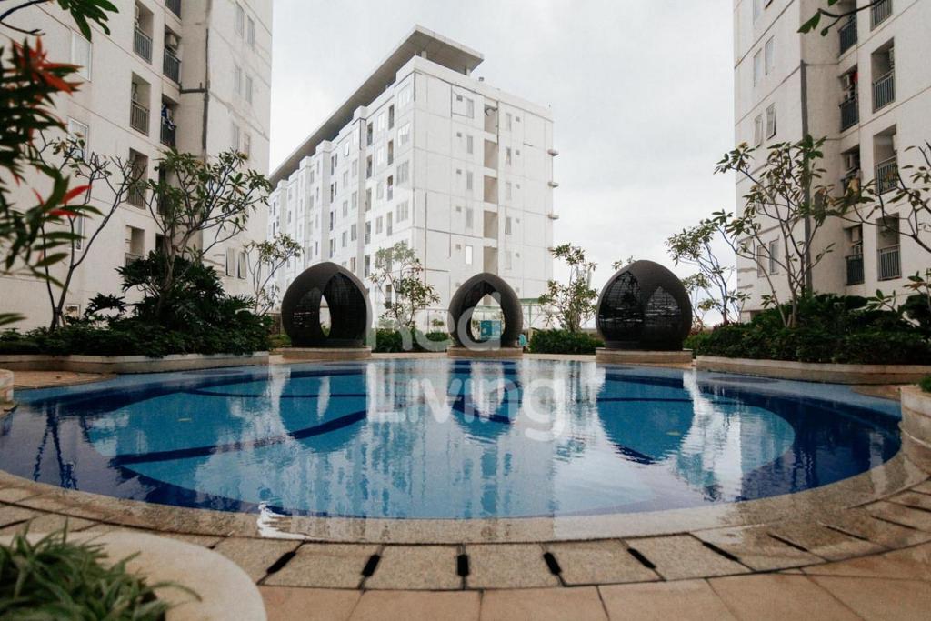 a large swimming pool in the middle of a building at RedLiving Apartemen Bassura City - Aokla Property Tower Dahlia in Jakarta